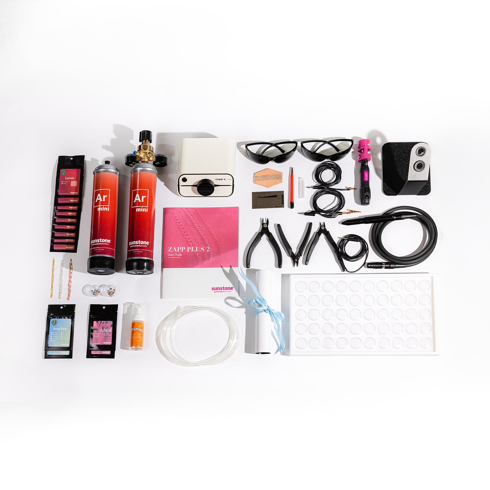 Zapp Plus 2 Collection of various items including bottles, tools, and electronic devices on a white background