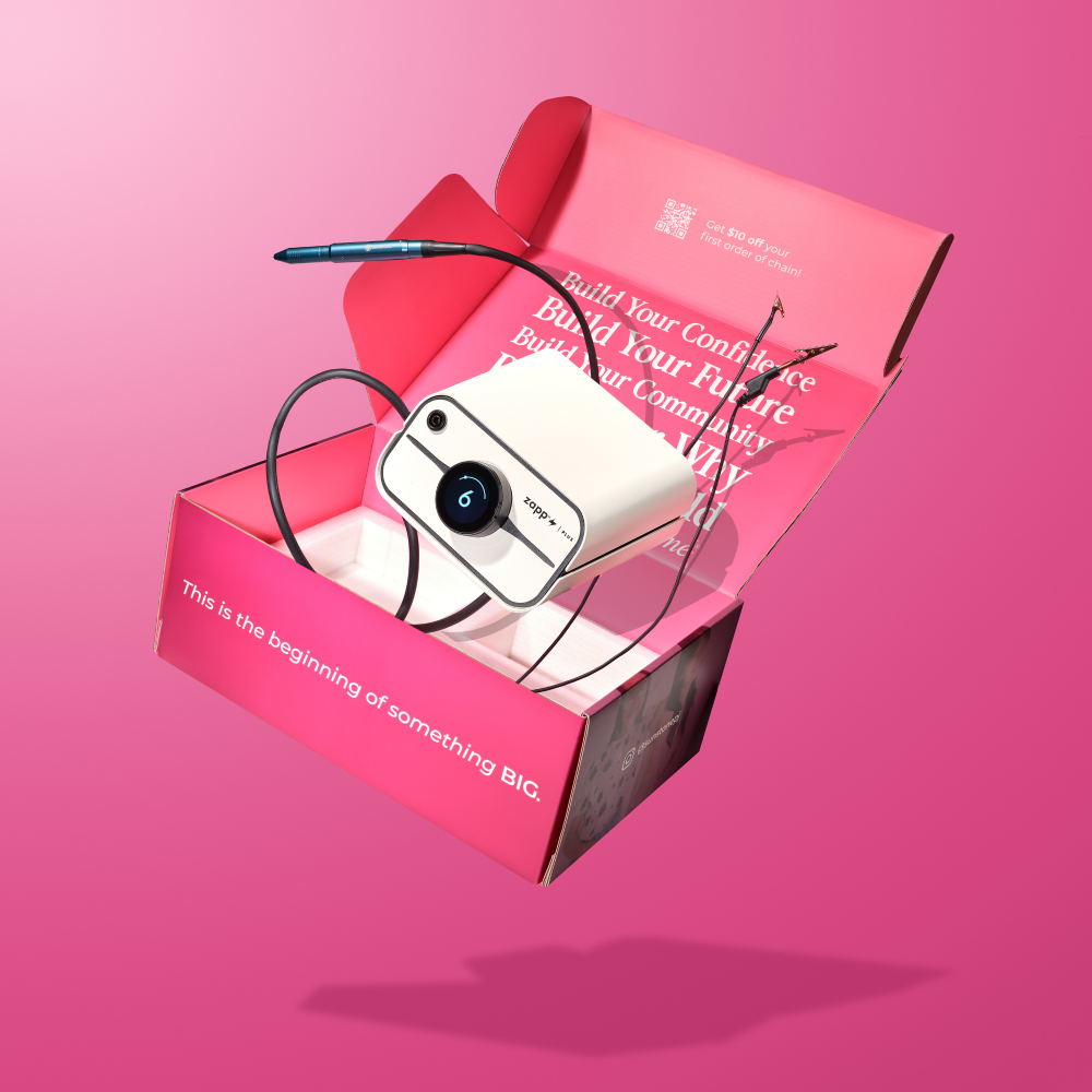 Zapp Plus 2 White camera with black strap inside a pink box on a pink background