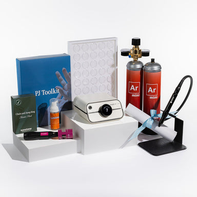 Zapp Plus 2 Collection of small items including a camera, bottles, and tools on a white surface.